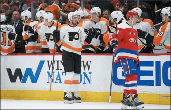  ?? NICK WASS — THE ASSOCIATED PRESS ?? Philadelph­ia Flyers center Kevin Hayes, center, celebrates his goal, as Washington Capitals defenseman John Carlson, right, skates nearby during the second period of an NHL hockey game Wednesday in Washington.