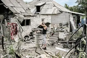  ?? ?? Maksym Katerin stands in the yard of his damaged house a er his mother and his step father were killed during shelling in the city of Lysychansk.