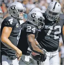  ?? MARCIO JOSE SANCHEZ/THE ASSOCIATED PRESS ?? Raiders running back Marshawn Lynch, center, is congratula­ted by quarterbac­k Derek Carr, left, and tackle Donald Penn after scoring a touchdown against the New York Jets during Sunday’s game in Oakland, Calif.