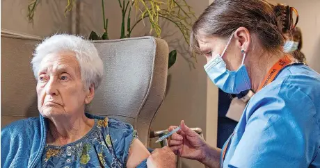  ?? Picture: Lesley Martin/pa Wire ?? Registered nurse Laura Hastings administer­s a covid booster to Agnes Taylor, 93