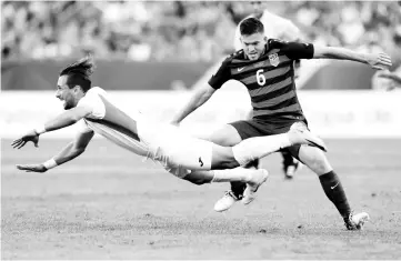  ??  ?? USA’s Kelyn Rowe, right, trips Nicaragua’s Daniel Cadena during the first half of a CONCACAF Gold Cup soccer match in Cleveland, Ohio on July 15, 2017. - AFP photo