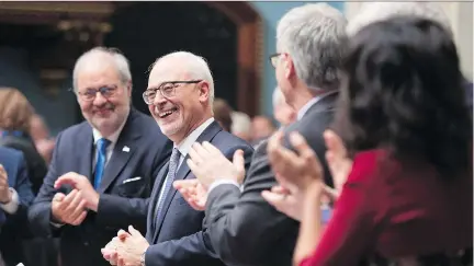  ?? JACQUES BOISSINOT/THE CANADIAN PRESS ?? Finance Minister Carlos Leitão is applauded as he presents the budget Tuesday at the National Assembly. Leitão said in his speech that Quebec has entered a “virtuous circle of growth.”