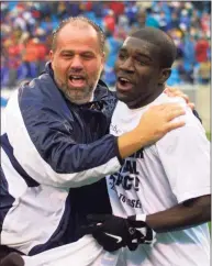  ?? Nell Redmond / Associated Press ?? UConn coach Ray Reid celebrates with Chris Gbandi after the Huskies defeated Creighton 2-0 in the NCAA men’s Division I championsh­ip game in 2000. Gbandi was named as the UConn men’s soccer coach on Friday.