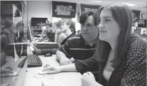  ??  ?? North Point High School graphics communicat­ions teacher Chris Gilbert, left, sees how freshman Alex Waltemyer’s DVD cover is coming along in class.