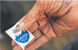  ?? RJ Sangosti, The Denver Post ?? J.B. Johnson holds an “I voted” sticker after making a choice at Denver election headquarte­rs during Colorado’s Super Tuesday presidenti­al primary.