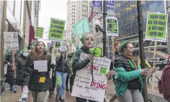  ?? TYLER PASCIAK LARIVIERE/SUN-TIMES ?? A few dozen activists march in downtown Chicago on Tuesday to oppose a leaked draft opinion from the U.S. Supreme Court that would end federal protection­s for abortion.