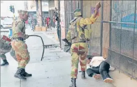  ?? REUTERS ?? n A painful transition: Soldiers beat up a supporter of the opposition in Harare.