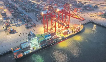  ?? ?? This photo taken on July 22, 2021 shows a cargo ship loaded with containers berthing at Lianyungan­g port, in China’s eastern Jiangsu province.