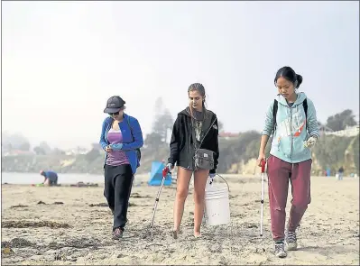  ?? KEVIN JOHNSON — SANTA CRUZ SENTINEL ARCHIVES ?? Sonja Fauske, from left, Emma Nelson and Jackie Zhao pick up pieces of trash as they walk along Cowell Beach in Santa Cruz in 2016 when Save Our Shores hosted the annual Coastal Cleanup event.