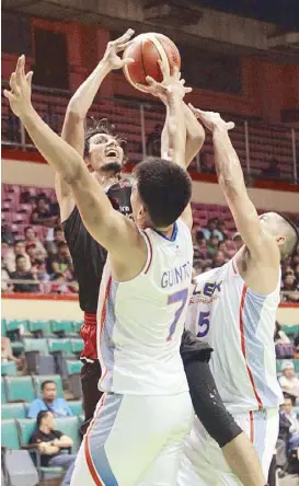  ??  ?? Alex Mallari of Mahindra defies the defense of Bradwin Guinto and Mac Baracael of NLEX during their match in the PBA Philippine Cup at the Cuneta Astrodome.