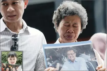  ?? PICTURES: REUTERS ?? A Mrs Wong and her son, Daniel Tan, hold a picture of her other son, Tan Chong Ling, who was on the missing Malaysia Airlines flight MH370, at a remembranc­e event in Kuala Lumpur, yesterday the anniversar­y of its disappeara­nce. LEFT: Jie Yie holds a...