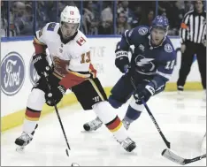  ?? O’MEARA AP PHOTO/CHRIS ?? Calgary Flames left wing Johnny Gaudreau (13) carries the puck past Tampa Bay Lightning left wing Ondrej Palat (18) during the third period of an NHL hockey game in 2018 in Tampa, Fla.