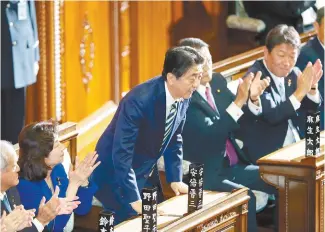  ?? EPA-Yonhap ?? Japanese Prime Minister Shinzo Abe is celebrated by his party’s lawmakers after being named as new prime minister of Japan at the opening session of the Lower House following the Oct. 22 election in Tokyo, Wednesday.
