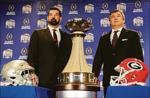 ?? John Bazemore / Associated Press ?? Ohio State head coach Ryan Day, left and Georgia head coach Kirby Smart stand with the trophy during a news conference on Friday ahead of Saturday’s Peach Bowl in Atlanta.