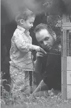  ?? LARS HAGBERG/THE CANADIAN PRESS ?? Joshua Boyle and his son Jonah play in the garden at his parents house in Smiths Falls in October.