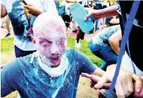  ??  ?? Milk is poured into a demonstrat­or’s eyes to neutralise the effect of pepper spray during a rally at Lafayette Park near the White House in Washington.