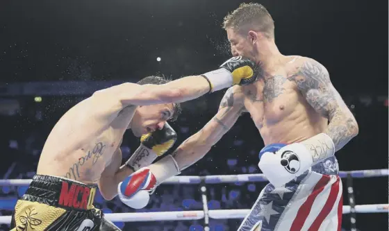  ??  ?? 2 Ricky Burns, right, and Anthony Crolla exchange blows during their lightweigh­t contest at Manchester Arena on Saturday night.