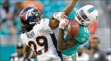  ?? ALLEN EYESTONE / THE PALM BEACH POST ?? Dolphins wide receiver DeVante Parker (right) can’t haul in a pass defended by Broncos safety Bradley Roby. It has been a disappoint­ing season for Parker, whose role continues to diminish.