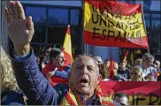  ?? PABLO BLAZQUEZ DOMINGUEZ / GETTY IMAGES ?? A supporter of Spain’s late dictator Gen. Francisco Franco does a fascist salute Sunday as others hold a banner reading “For the Unity of Spain” at a Madrid rally on the 42nd anniversar­y of his death.