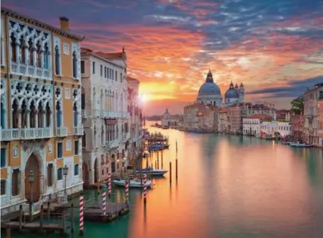  ?? GETTY IMAGES PHOTOS ?? TINTED VIEW: The setting sun colors the canals of Venice, Italy.