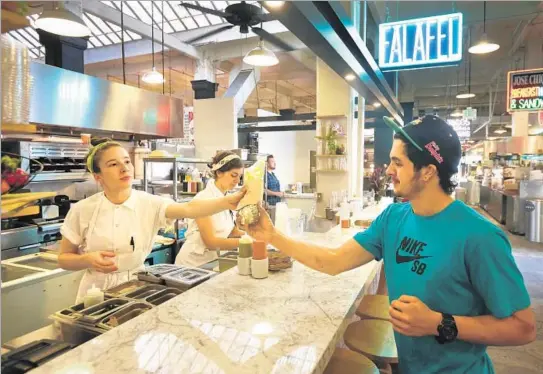  ?? Photograph­s by Mel Melcon
Los Angeles Times ?? CHEF SARAH HYMANSON serves Ryan Badaraco at Madcapra in Grand Central Market. Hymanson and Sara Kramer, middle, were at Glasserie in Brooklyn.