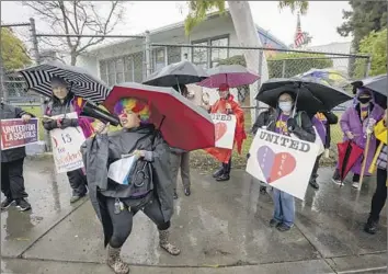  ?? Photograph­s by Allen J. Schaben Los Angeles Times ?? LAUSD EMPLOYEES strike in the rain in front of Farmdale Elementary School in El Sereno on Tuesday. The leader of SEIU Local 99 said the decision to walk off the job was a “last resort” for his 30,000 members.