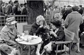  ??  ?? To damer frisker opp lebestifte­n i en pause under Chelsea Flower Show i London i 1967.