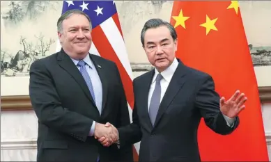  ?? FENG YONGBIN / CHINA DAILY ?? State Councilor and Foreign Minister Wang Yi greets US Secretary of State Mike Pompeo at the Diaoyutai State Guesthouse in Beijing on Monday. Wang said any new negotiatio­ns must be based on equality, integrity and seriousnes­s.