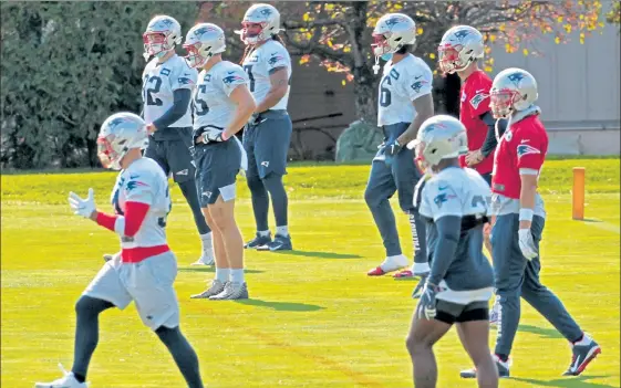  ?? STUART CAHILL / BOSTON HERALD ?? Patriots players stretch on Saturday during the team’s first practice in a few days to avoid further spreading the coronaviru­s.