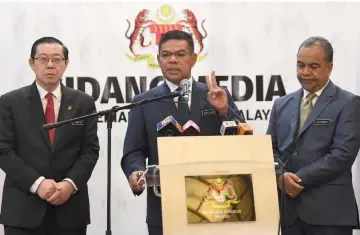  ??  ?? Saifuddin speaks at the media conference, flanked by Lim and Deputy Finance Minister Datuk Ir Amiruddin Hamzah— Bernama photo