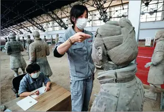  ?? CHEN FEIBO / FOR CHINA DAILY ?? A technician measures a Terracotta Warrior before starting repair work at the Emperor Qinshihuan­g’s Mausoleum Site Museum in Xi’an, Shaanxi province, on Friday.