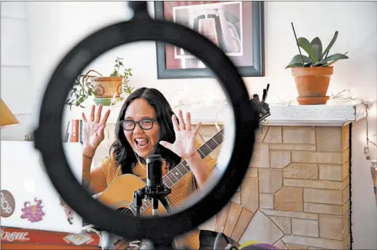  ?? STACEY WESCOTT/CHICAGO TRIBUNE PHOTOS ?? Ann Torralba, aka Little Miss Ann, performs from home during a live virtual music class for the Chicago Public Library on Dec. 4.