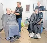  ??  ?? Greg Johnson, left, who is homeless but in transition­al housing, gets a free haircut along with Sylvester Demps, right, who is also homeless, at Matthew’s Hope Outreach Center in Winter Garden.