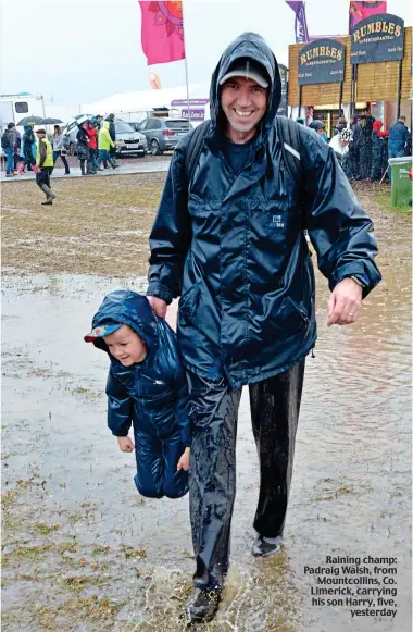  ?? ?? Raining champ: Padraig Walsh, from Mountcolli­ns, Co. Limerick, carrying his son Harry, five, yesterday