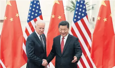  ?? LINTAO ZHANG THE ASSOCIATED PRESS FILE PHOTO ?? Chinese President Xi Jinping, right, shakes hands with then-U.S. vice-president Joe Biden in 2013. Beijing is winning the global power game, which could explain why China is now being singled out, Thomas Walkom writes.