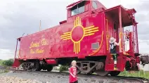  ?? RACHEL WALKER/THE WASHINGTON POST ?? The author’s sons explore an old railcar secured on the tracks during a visit to the Santa Fe Railyard.