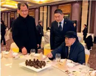  ??  ?? 蒋洪在全塘宴发布会上­与师父华永根（右）和徒弟钱立新（中）品评菜肴的“形”和“色”