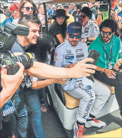  ?? FOTO: EFE ?? Fernando Alonso, envuelto de aficionado­s de camino a la pista, unos hinchas que le consideran un ídolo en la parrilla de la Indy500