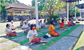  ?? AHMAD KHUSAINI/JAWA POS ?? TETAP JAGA JARAK: Umat Hindu beribadat dalam rangka Piodalan dan Saraswati di Pura Agung Jagat Karana kemarin.