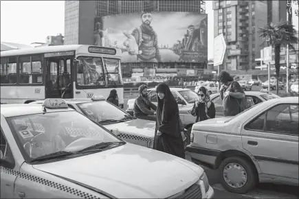  ?? PHOTOS BY ARASH KHAMOOSHI / THE NEW YORK TIMES ?? A billboard in Tehran, Iran, depicts Mohsen Hojaji, the once-obscure 26-year-old who was killed fighting in Syria. After having been taken prisoner, videotaped and later beheaded by the Islamic State in August, Hojaji has been transforme­d by Iran’s...