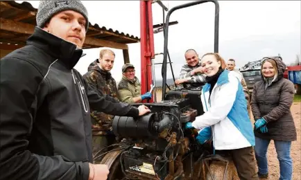  ??  ?? Avec Antoine Arnaud (au premier plan) qui les forme au métier de tractorist­e, une partie du groupe met les mains dans le cambouis. Plusieurs femmes suivent la formation, où la mécanique ne leur fait pas peur.