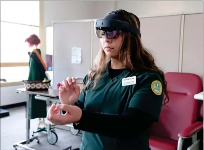  ?? COURTESY FITCHBURG STATE UNIVERSITY ?? Fitchburg State Nursing student Kaleigh Visbaras uses an AR headset from Gig XR, who created a holographi­c healthcare training platform wherein students and faculty may interact with lifelike virtual patients in augmented reality.