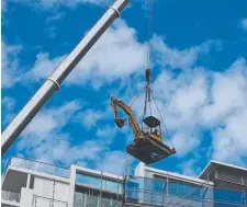  ?? Picture: GLENN HAMPSON ?? An excavator is lowered into the Mimi Macpherson-built Aspect on Burleigh tower as demolition work begins.