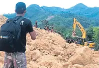  ??  ?? Rescuers search for missing people beneath the rubble