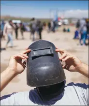  ?? (File Photo/AP/Natacha Pisarenko) ?? Using a welder’s mask as protection, a man views a total eclipse Dec. 14, 2020, in Piedra del Aguila, Argentina.