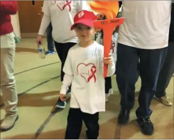  ?? SUBMITTED PHOTO ?? Jaxon Hayes, 5, of Rome, carries a torch as he participat­es in the Rome Run &amp; Indoor Walk at the Rome Free Academy on Saturday, Feb. 9, 2019.