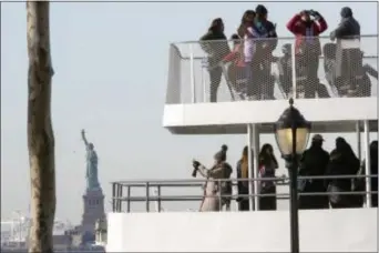  ?? MARY ALTAFFER - THE ASSOCIATED PRESS ?? Visitors to the Statue of Liberty take photos from onboard a ferry that will cruise the bay around the statue and Ellis Island, Saturday in New York. The National Park Service announced that the Statue of Liberty and Ellis Island would be closed...