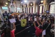  ?? RINGO H.W. CHIU — THE ASSOCIATED PRESS FILE ?? People hold signs and shout slogans in Los Angeles on Wednesday as they protest before the cancellati­on of the City Council meeting.