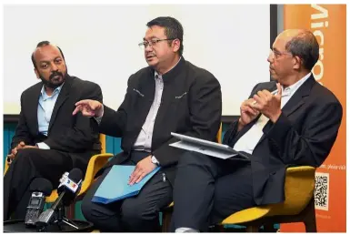  ?? — FAIHAN GHANI/The Star ?? (From left) Frost & Sullivan Asia Pacific vice-president Sapan Agarwal, Amirudin and Dzahar going over a study by Microsoft and Frost & Sullivan on the state of cybersecur­ity in the region.