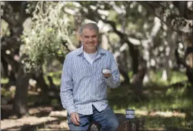  ?? PHOTO BY DAVID ROYAL ?? Tom Radcliffe, owner of Muridae Pet, holds a can of his Mouser cat food in the forest in Pacific Grove on April 20.